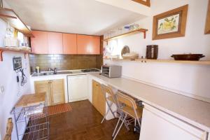 a kitchen with white cabinets and a counter top at Villino Lacona in Capoliveri +12 photos