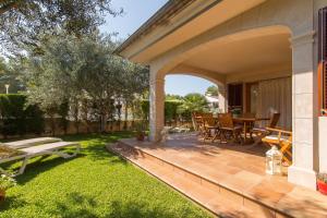 an outdoor patio with a table and chairs at Calma in Son Serra de Marina