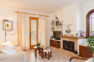 a living room with a couch and a fireplace at Calma in Son Serra de Marina