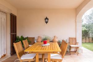 a wooden table and chairs in a porch with a table and chairsktop at Calma in Son Serra de Marina