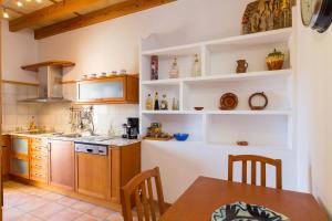 a kitchen with wooden cabinets and a table at Can Olivera in Llubí
