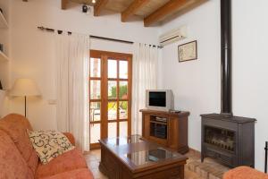 a living room with a couch and a tv and a fireplace at Can Olivera in Llubí