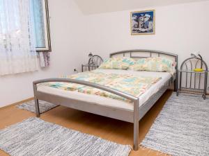a bed with a metal frame in a bedroom at Apartments Vukovic in Postira
