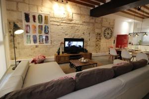 a living room with a couch and a tv at Casa Mercat in Sa Pobla