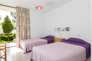 2 camas en una habitación con ventana en Mollet, en Puerto de Alcudia