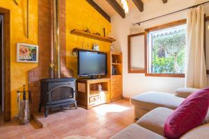 a living room with a television and a stove at Alga Marina in Son Serra de Marina