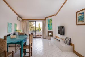 a living room with a blue table and a tv at BmyGuest - Quinta do Lago Lounge Apartment in Almancil