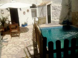 - une piscine dans une maison avec un parasol dans l'établissement La Serrana, à Bedmar