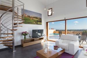 a living room with a white couch and a spiral staircase at Sa Riba in Muro