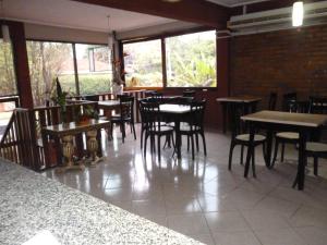 a dining room with tables and chairs and windows at Petit Hotel Panambi in Puerto Iguazú