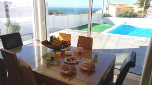 a table with a bowl of food and a bowl of fruit at Nira House Luxury & Simplicity in Ericeira