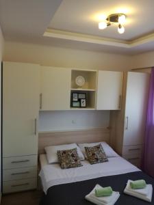1 dormitorio con 1 cama con sábanas y almohadas blancas en Apartments Lipić, en Posedarje