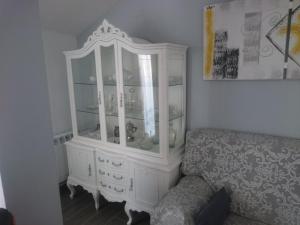 einen weißen Schrank im Wohnzimmer mit Sofa in der Unterkunft La terraza de Maxi Casa completa in Cuenca