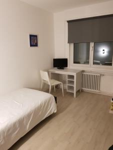 um quarto com uma cama, uma secretária e uma televisão em Hotel Elite em St. Gallen