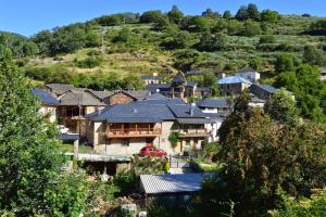 een groep huizen op een heuvel met bomen bij Casa de Abril 1 in San Cristóbal de Valdueza