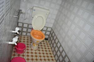a small bathroom with a toilet in a stall at Adarsh Niwas in Malvan