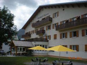 a hotel with tables and umbrellas in front of it at Le Collet d'Auron in Auron +11 photos