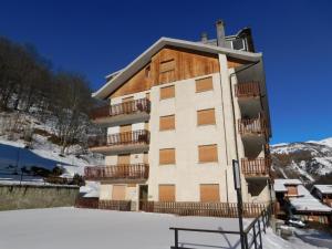 a building in the snow with a bench in front of it at Casa Soleil by Holiday World in Limone Piemonte