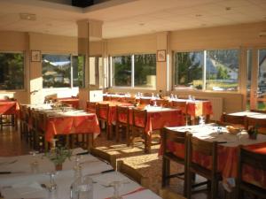 a restaurant with tables and chairs with red table cloth at Le Collet d'Auron in Auron