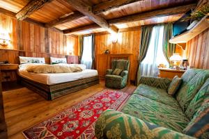 1 dormitorio con 1 cama y 1 sofá en Hotel Jolanda Sport, en Gressoney-la-Trinité