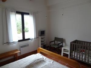 1 dormitorio con cuna, cama y ventana en Ferienhaus Schulenburg, en Grand-Village-Plage