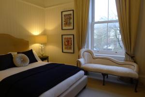 a bedroom with a bed and a window and a bench at Trinity Boutique B&B in Peterhead