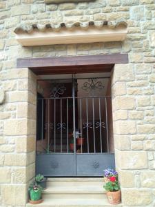 a window of a brick building with two potted plants at FIGONERO 4-6 in Las Peñas de Riglos