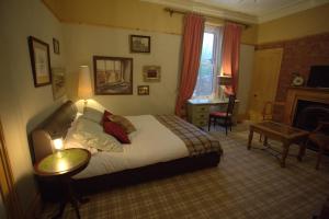 a bedroom with a bed and a table and a desk at Trinity Boutique B&B in Peterhead
