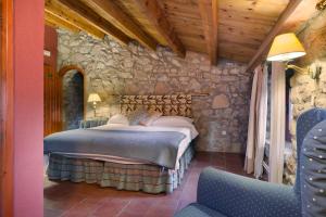 a bedroom with a bed in a stone wall at Sant Marçal del Montseny in Montseny