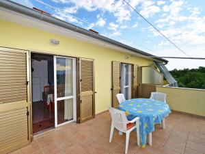a patio with a table and chairs on a balcony at Apartment Dada-2 by Interhome in Omišalj +20 photos