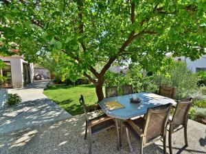 a blue table and chairs under a tree at Apartment Damir-2 by Interhome in Crikvenica