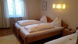 a bedroom with two beds with white pillows at Sportpension Sonnhof in Taxenbach