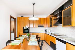 a kitchen with a long wooden table with chairs at Attico Ai Cedri in Verona