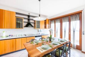 une cuisine avec une table en bois et quelques chaises dans l'établissement Attico Ai Cedri, à Vérone 6 autres photos