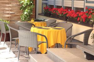 a group of tables and chairs with flowers on a patio at Sportpension Sonnhof in Taxenbach