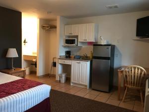 a room with a kitchen with a refrigerator and a table at Cactus Tree Inn in Oliver