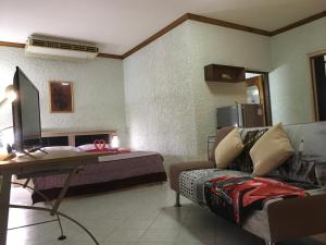 um quarto com uma cama, uma secretária e um sofá em Peaceful homestay em Rawai Beach