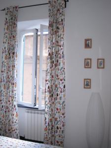 a bedroom with a window with a curtain at Una Porta sul Porto Antico in Genova