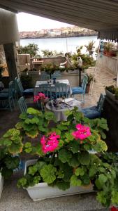 una mesa y algunas flores rosas en el patio en Farlalievi Guest House en Sozopol