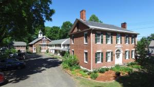 an old brick house with a car parked in front of it at The Black Walnut Inn in Amherst