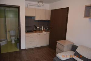 a small kitchen with white cabinets and a toilet at Apartamenty i pokoje "U Dawida" in Mrzeżyno +55 photos