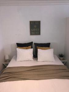 ein Bett mit zwei Kissen und ein Schild an der Wand in der Unterkunft Studio Ostend Living in Ostende