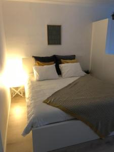 una camera da letto con un grande letto con lenzuola bianche e cuscini gialli di Studio Ostend Living a Ostenda