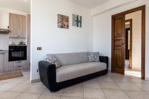 un sofá en una sala de estar con cocina en Casa Mattarella en San Vito lo Capo