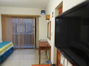 sala de estar con TV de pantalla plana grande en Hotel Pastora, en Córdoba