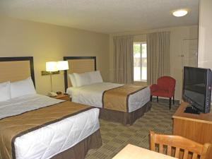 a hotel room with two beds and a flat screen tv at Extended Stay America Suites - Albuquerque - Airport in Albuquerque