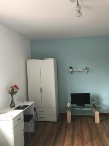 Cette chambre comprend un bureau et une armoire blanche. dans l'établissement Pension32, à Burg bei Magdeburg