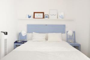 リスボンにあるAlfama Skyのベッドルーム1室(白いベッド1台、ランプ2つ、棚2つ付)