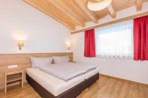 1 dormitorio con cama y ventana roja en Apart Ida en Sölden