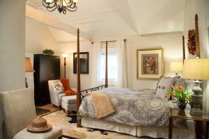 a bedroom with a bed and a chair and a table at The Inn & Tavern at Meander in Locust Dale